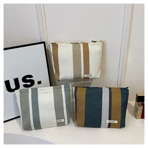 Detailed view of striped canvas cosmetic bags, large capacity storage for travel daily use.