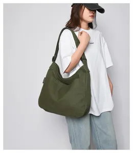 Green canvas shoulder bag detail view showing large capacity and comfortable strap design.