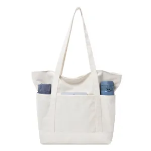 Minimalist white canvas tote bag with multiple front pockets for women, casual shoulder bag.