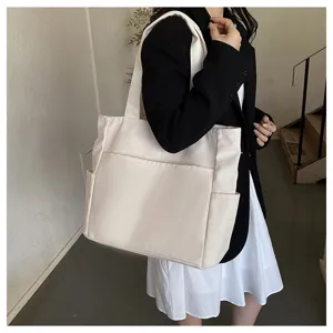 Casual white canvas tote bag on model, featuring large capacity and practical side pockets.