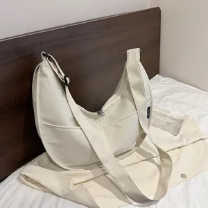 Close-up detail of the casual canvas crescent shoulder bag with front pocket and strap.