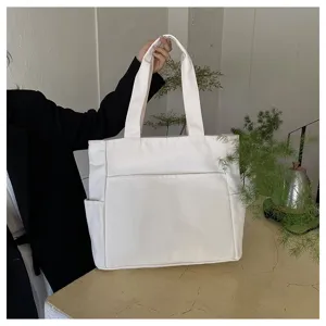 White canvas tote bag large capacity solid shoulder handbag detail view for daily commute.