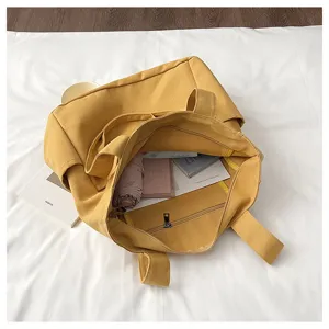 Detail view of large capacity yellow canvas tote bag showing interior space and practical storage design.