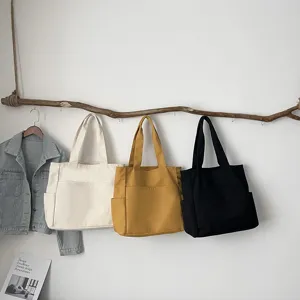 Large capacity solid color canvas tote bag for women, casual minimalist shoulder handbag.