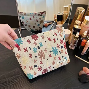 Linen jacquard cosmetic bag travel toiletry pouch with floral pattern and zipper closure.