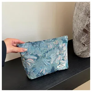 Detailed close-up view of the stylish blue floral jacquard cosmetic storage bag for women.