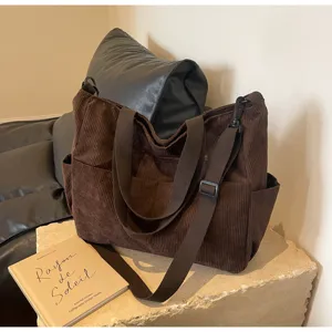 Detailed view of the brown corduroy shoulder tote bag showcasing soft textured fabric and pockets.