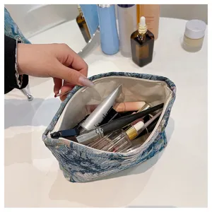 Detailed view of vintage blue floral linen cosmetic bag, ideal for daily makeup storage.