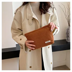 Close-up detail shot of the brown corduroy cosmetic pouch showcasing fine fabric texture.