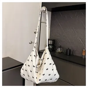 White canvas shoulder tote bag featuring cute black bow print, casual Korean style daily bag.