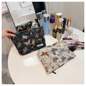 Detailed view of vintage butterfly pattern linen cosmetic bag, stylish makeup storage pouch.