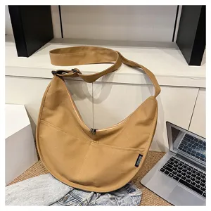 Vue détaillée d'un sac bandoulière décontracté en toile kaki avec fermeture éclair et poche.