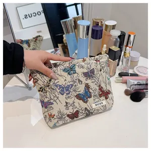 Detailed view of linen makeup bag with colorful butterfly floral print and woven label.