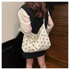 Casual canvas tote bag for women featuring cute black bow prints, perfect for daily wear.
