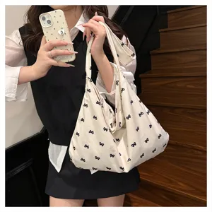 Canvas shoulder tote bag featuring a chic black bow print, casual and stylish daily accessory.