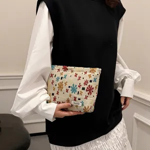 Close-up detail of vintage floral jacquard cosmetic pouch, elegant linen storage bag design.