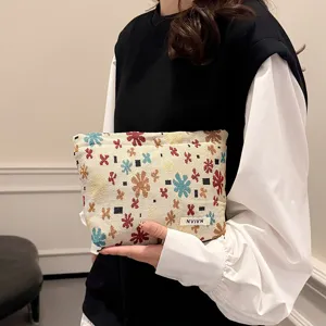 Woven jacquard cosmetic bag with colorful floral pattern, portable travel makeup pouch.
