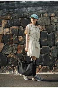Black canvas tote bag for women, casual shoulder bag with multiple pockets and sturdy handles.