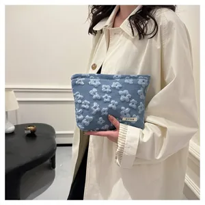 Detailed view of the blue floral textured makeup pouch, showing soft fabric and stylish daily design.