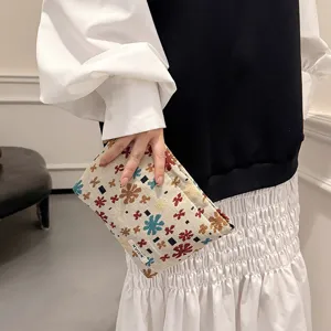 Linen jacquard cosmetic pouch detail view, vintage floral pattern travel makeup storage bag.