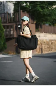 Black canvas tote bag detail view, large capacity casual shoulder bag for women daily use.