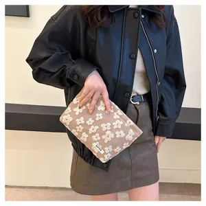 Detailed view of brown floral quilted pouch showing delicate fabric texture and practical design.