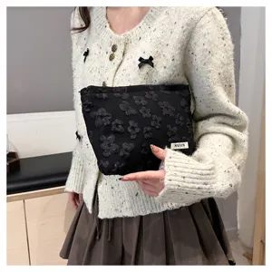 Detailed view of the black floral cosmetic pouch, showcasing texture and elegant design.