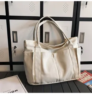Casual white canvas tote bag with multiple exterior pockets for daily use and travel storage.