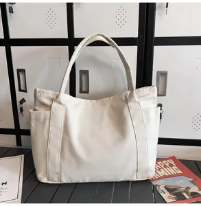 White canvas tote bag with shoulder straps and side pockets, detailed view of casual daily bag.