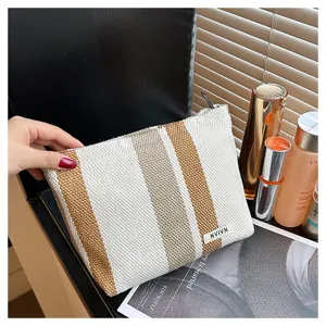 Detailed view of the striped linen cosmetic bag, showcasing textured fabric and sturdy zipper.