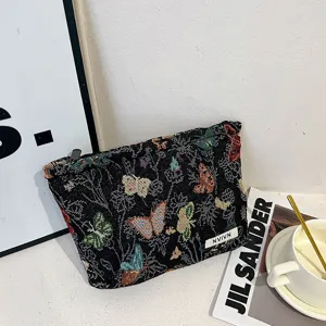 Woven fabric cosmetic bag with colorful butterfly pattern, stylish makeup pouch for women.