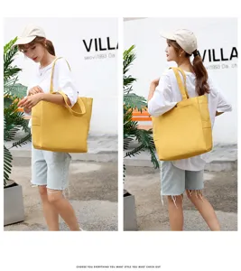 Detail view of the yellow canvas tote bag showing shoulder strap and side pocket design.