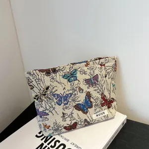 Detailed view of the woven makeup pouch featuring colorful butterfly floral pattern storage.