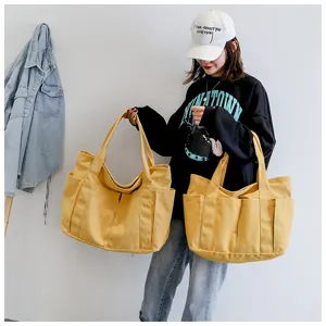 Yellow canvas tote bag for women, large capacity casual shoulder bag with multiple pockets.