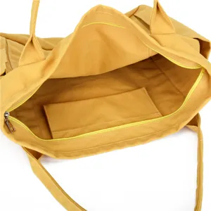 Detailed view of the yellow canvas tote bag showing the spacious interior and zipper pocket.