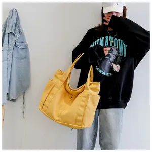 Stylish large capacity yellow canvas tote bag with multiple pockets for daily use.