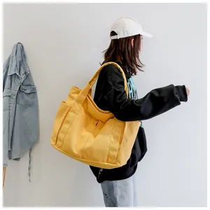 Fashion large capacity canvas shoulder bag for women, casual yellow multi-pocket tote handbag.