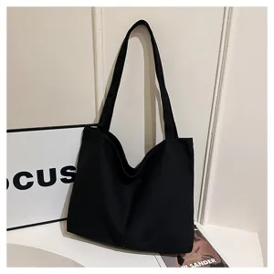 Black canvas tote bag detail, casual minimalist shoulder bag for daily commuting and shopping.