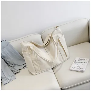 Canvas tote bag detail view, large capacity casual shoulder bag with side pockets, off-white.