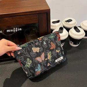 Black woven cosmetic bag featuring colorful butterfly pattern, large capacity daily storage pouch.