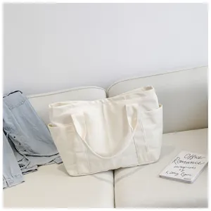 Minimalist cream canvas tote bag with side pockets, casual large capacity shoulder bag for daily use.