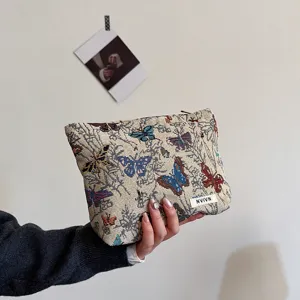 Close-up of the woven cosmetic pouch featuring detailed colorful butterfly patterns and neat stitching.