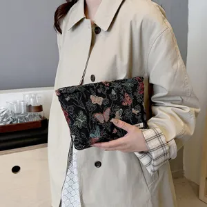 Detailed close-up view of the black woven cosmetic pouch showcasing intricate butterfly patterns.