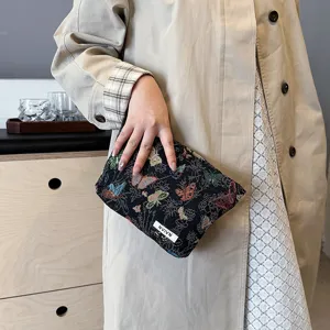 Close-up detail of the stylish woven cosmetic bag featuring colorful butterfly patterns, compact design.