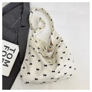 Casual canvas shoulder tote bag with cute black bowknot print, large capacity daily handbag.