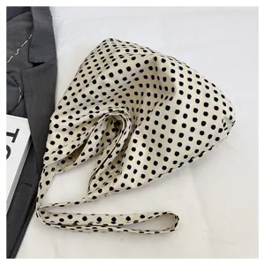 Detailed shot of a casual polka dot canvas shoulder bag with a stylish slouchy design.