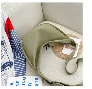 Sac bandoulière croissant en toile verte détail, avec tissu résistant et doubles fermetures.