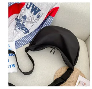 Vue détaillée du sac à bandoulière noir stylé en toile, grand format croissant design.