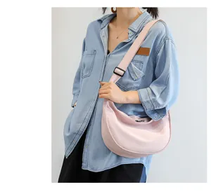 Vue détaillée du sac bandoulière en toile rose, style croissant décontracté pour un usage quotidien.