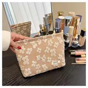 Detail shot of the beige cosmetic pouch featuring textured floral patterns and a portable design.